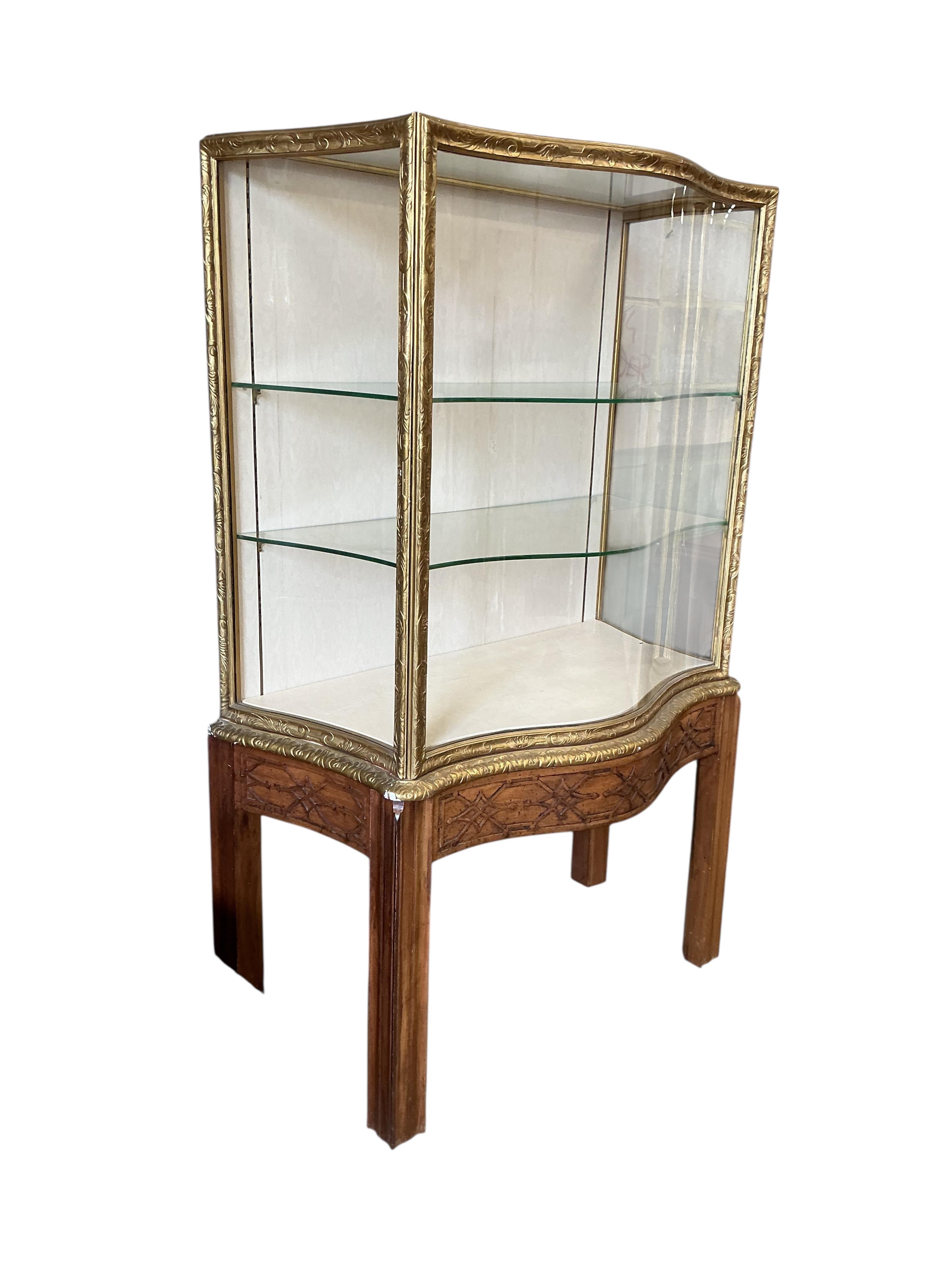 A George III style mahogany and giltwood serpentine display cabinet on blind fret stand, width 106cm, depth 60cm, height 181cm